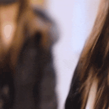 a close up of a woman 's hair with a blurry background behind her