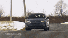 a car is driving down a snowy road with motorweek.org written on the bottom