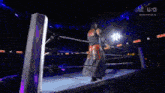 a man is standing in a wrestling ring with a rope around his waist .