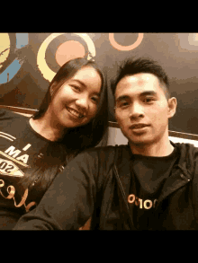 a man and a woman are posing for a picture and the man is wearing a shirt that says i ma 02