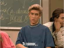 a man sitting in front of a chalkboard that says friday on it