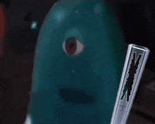 a blue object with a red eye is next to a remote