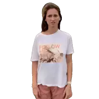 a woman wearing a white t-shirt that says follow me on it