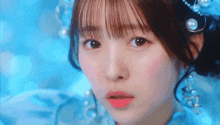 a close up of a girl 's face wearing a blue dress