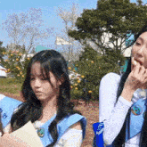 a girl wearing a blue vest with a badge on it