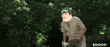 a man wearing a green hat and goggles is throwing a baseball and the word $ dood is on the bottom
