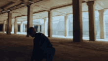 a silhouette of a person in a dark hallway with columns