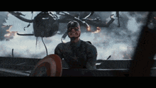 a man in a captain america costume holds a shield