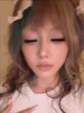 a close up of a woman 's face with her eyes closed and a cat ear on her head