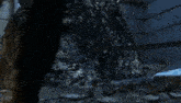 a person is standing in a dark cave with a glowing light coming out of the ceiling .