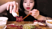 a woman is holding a spoon over a plate of food
