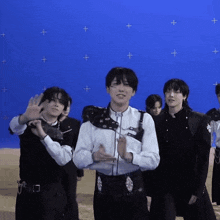 a group of young men are standing in front of a blue background