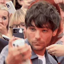 a man is taking a picture of himself with a cell phone