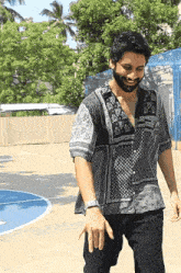 a man wearing a bandana shirt is standing in front of a blue basketball court