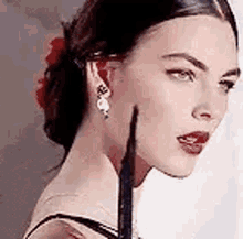 a close up of a woman 's face with a flower in her hair .