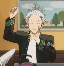 a man is holding a spoon in his hand and smiling while sitting at a table .
