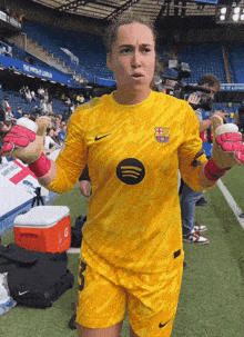a female soccer player wearing a yellow nike jersey with the number 3 on it