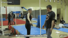 a man and a woman are standing in a gym and the man is saying me estás mintiendo todo el rato