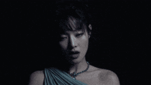a close up of a woman 's face with a necklace around her neck