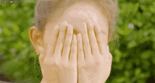a woman covering her face with her hands and the word nacific is visible