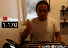 a man in a white shirt is standing in front of a toaster with a sign that says 1,170