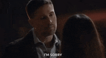 a man and a woman are looking at each other and the man is saying i 'm sorry .