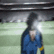 a blurry picture of a soccer player standing on a field .