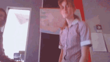 a woman in a striped shirt is standing in front of a map on the wall