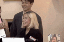 a man and a woman are standing next to each other and laughing .