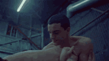 a shirtless man is laying on top of a woman in a dark room