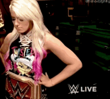 a woman in a wrestling shirt is holding a wwe belt around her waist