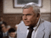 a man in a suit and tie stands in a courtroom