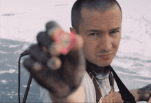 a man with a tattoo on his hand is holding a pink object