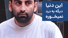 a man with a beard is standing in front of a blue sign that says ' iran dunia ' on it