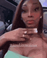 a woman is sitting in the back seat of a car holding her chest .