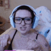 a woman wearing headphones and glasses is sitting in a chair .