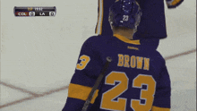 a hockey player wearing a purple jersey with the number 23 on it