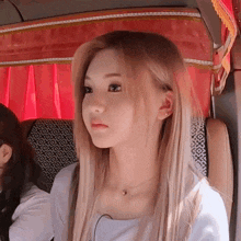 a woman with long blonde hair is sitting in a chair