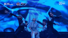 a group of people dancing on a stage in front of a screen that says ' we are k pop ' on it
