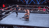 two men are wrestling in a wrestling ring with a referee in the background