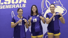 three female athletes are posing for a picture in front of a sign that says lsua generals