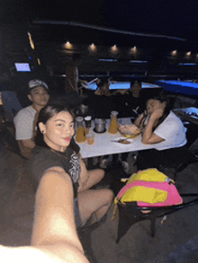 a group of people are sitting at a table with drinks