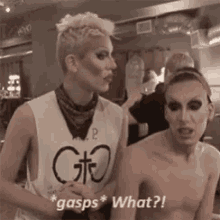 a man and a woman are standing next to each other and the woman is wearing a tank top that says " gasps what "