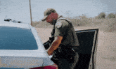 a police officer is standing next to a car
