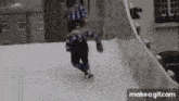 a person is ice skating on a snowy slope while another person watches .