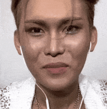 a close up of a woman 's face with earbuds in her ears