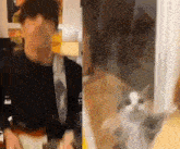 a man is playing a guitar next to a cat that is looking at him .