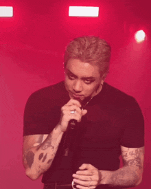 a man with a tattoo on his arm is holding a microphone