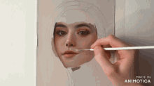 a person is painting a woman 's face with a brush and the words made in animotica are on the bottom