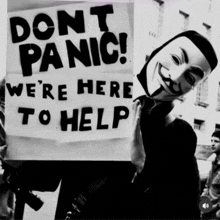 a man holding a sign that says " do n't panic "
